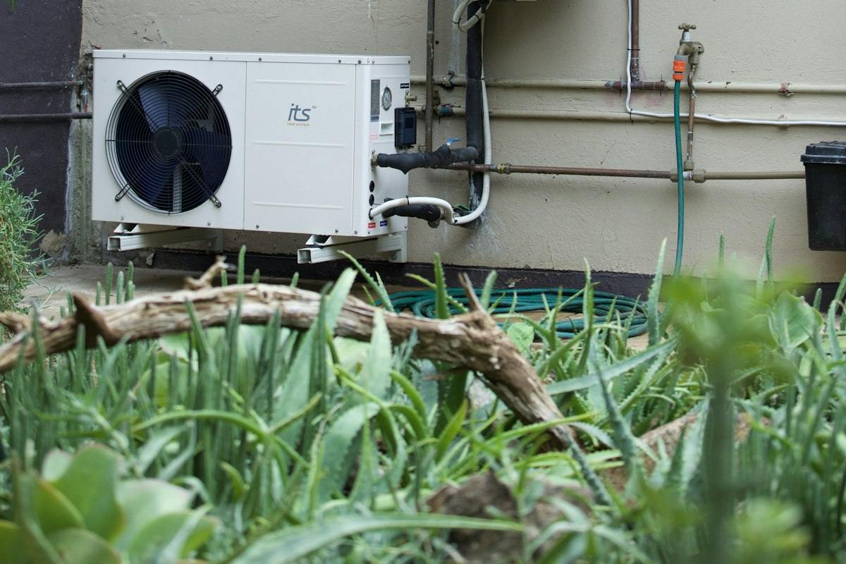 Outdoor water heater and air-conditioning units mounted beside a home